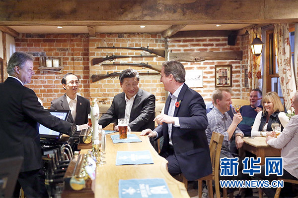 這是會晤結(jié)束后，習近平在卡梅倫陪同下乘車前往當?shù)匦℃?zhèn)體驗酒吧文化。新華社記者 鞠鵬 攝